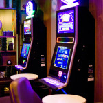 Two glowing slot machines in front of modular shelving